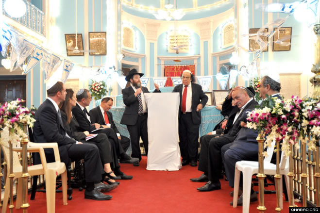 Chabad-Lubavitch of Mumbai director Rabbi Chanoch Gechtman, center left, and local Jewish community leader Solomon Sopher talked about the importance of Chanukah for a delegation of dignitaries at the Indian financial capital’s historic Knesset Eliyahu synagogue.