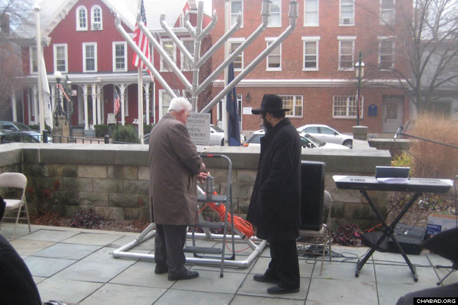 Blair County Sheriff Mitch Cooper helps light the Chanukah menorah with Rabbi Yossi Stein, director of the Chabad-Lubavitch Jewish Center of Greater Altoona, Pa.