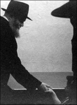 The Rebbe, of righteous memory, shakes a child&#39;s hand.