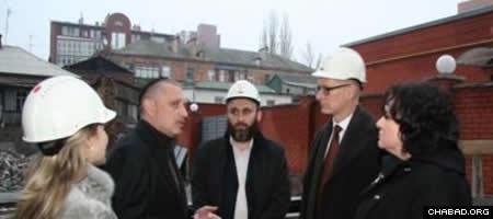German Consul General Klaus Zillikens, second from right, gets a briefing on construction at the Menorah Jewish Center in Dnepropetrovsk, Ukraine, from project manager Gennady Axelrod. (Photo: Dnepropetrovsk Jewish Community)