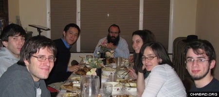 Rabbi Yossi Brackman, center, and students enjoy a meal at the Chabad-Lubavitch Jewish Center at the University of Chicago and Hyde Park.