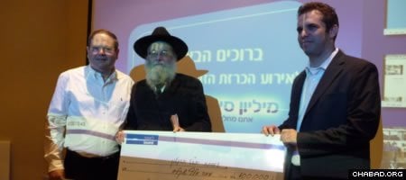Google Israel CEO Meir Brand presents a symbolic check for 100,000 to Chai Ashkelon director Rabbi Menachem Lieberman, whose organization placed second in Bank Leumi’s “A Million Good Reasons” online competition.