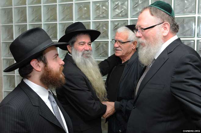 Chabad-Lubavitch Rabbi Mendy Mathless, left, who gave one of his kidneys to Yisrael Konstantini, second from left, chats with Rabbi Avrohom Lider, the Brooklyn, N.Y., rabbi who made the donation possible, at a Jan. 10 celebratory dinner in Konstantini’s hometown of Netanya, Israel.