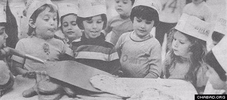 Torah Academy students in Minneapolis marvel at the handmade matzah they made at a model bakery run by Rabbi Gershon Grossbaum in 1977. (Photo: Minneapolis Star/Steve Schluter)