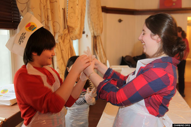 Jewish children don latex gloves before working with the flour and water that will become matzah.