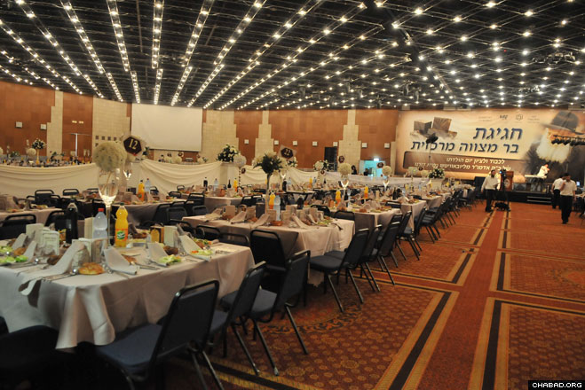 Tables and chairs for 1,500 people stood ready at Jerusalem’s International Conference Center for a party celebrating the mass Bar Mitzvah of 110 boys from needy families coordinated by Colel Chabad.