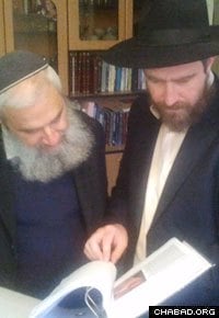 Rabbi Yossi Swerdlov, right, from Chabad’s Terror Victims Project, reviews letters with a member of the extended Fogel family.