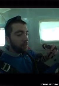 While wearing tefillin, student Michael Eisenberg concentrates on his prayers while ascending to the jump point.