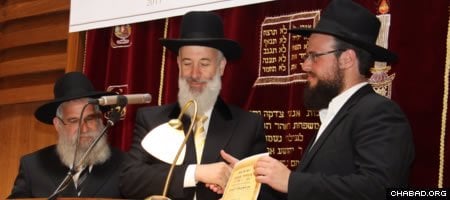 Israeli Chief Rabbi Yona Metzger, center, confers an ordination certificate on one of six graduating rabbis from Berlin’s Yeshiva Gedola.