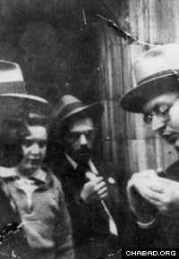 Le Rabbi, à gauche sur la photo, examine du matériel éducatif destiné aux enfants avec un jeune volontaire étudiant. (Photo: Lubavitch Archives)
