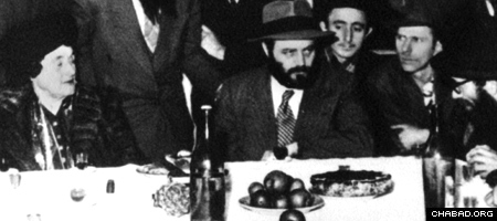 Rebetsin Chana Schneerson sentada ao lado de seu filho e futuro Rebe, Rabino Menachem M. Schneerson, de abençoada memória, em uma reunião chassídica em Paris, onde ele foi cuidar de sua mãe e trazê-la para os Estados Unidos. (Foto: Arquivos Lubavitch)