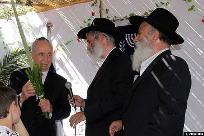 Kfar Chabad Mayor Rabbi Yami Lifshitz gave Israeli President Shimon Peres a set of the Four Species to make a special blessing in the presidential sukkah in Jerusalem. (Photo: Yosef Avi Yair Angel)