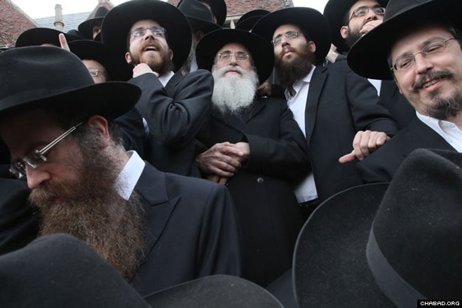 Rabbi Dovid Teichtel of Israel, center, waits with other Chabad-Lubavitch emissaries to have a group picture taken in front of Chabad-Lubavitch world headquarters in the Crown Heights section of Brooklyn, N.Y.