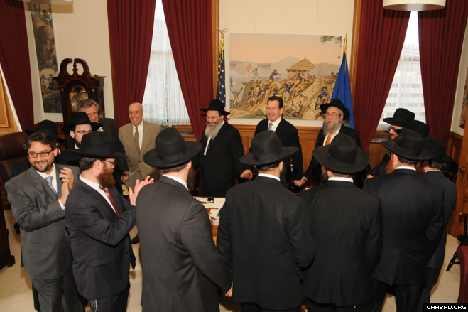 A delegation of rabbis representing the 23 Chabad-Lubavitch centers throughout Connecticut danced with Gov. Dannel P. Malloy during a Chanukah celebration in his capitol office.