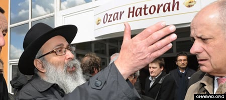 A distraught Chabad-Lubavitch Rabbi Yosef Matusof, who lost three students of his Gan Rashi elementary school in Monday&#39;s attack, seeks answers outside the Ozar Hatorah high school just meters from where they were slain. (Photo: Eric Cabanis/AFP/Getty)