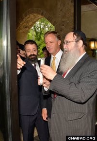 Rabbi Shlomo Tiechtel, father of Rabbi Yitzchok Tiechtel, affixes a mezuzah to the entryway of the new center in Nashville.