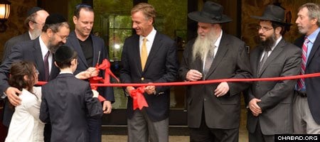 Rabbi Yitzchok Tiechtel helps his children Levi and Chana present the ceremonial ribbon cutting scissors to Tennessee Gov. Bill Haslam, who joined Rabbi Moshe Kotlarsky, vice chairman o Merkos L'Inyonei Chinuch, the education arm of Chabad-Lubavitch, for the grand opening of the Genesis Campus for Jewish Life.