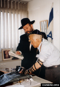 The former prime minister dons the prayer boxes known as tefillin with Rabbi Yosef Gerlitzky on occasion of his birthday, circa 1998. (Photo: Lubavitch Archives)