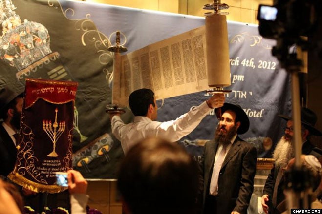 The new Torah scroll was opened for everyone to see.