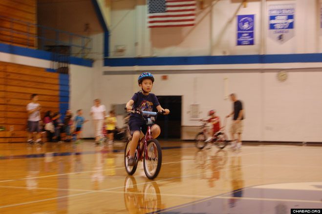 A boy with special needs rides a standard bicycle after mastering a “user-friendly” bicycle provided by the Friendship Circle and Lose the Training Wheels.