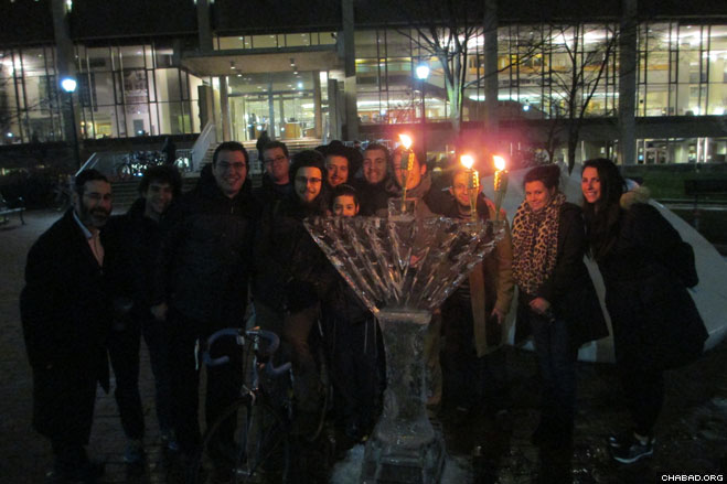 Students at the University of Pennsylvania gather with Rabbi Levi Haskelevich (left) co-director of Lubavitch House at the University of Pennsylvania. Around a menorah sculpted from ice.