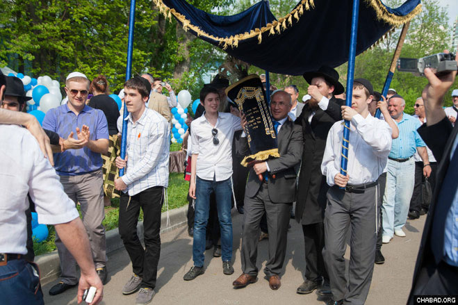 Local residents and guests dance in the streets of Moscow with their new Torah scroll.