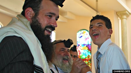 Parker Lynch celebrates his bar mitzvah at Chabad of Poway with Rabbi Mendy Rubenfeld, left and Rabbi Yisroel Goldstein, center.