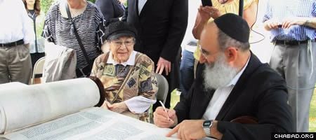 Congregants, family members and well-wishers took turns sitting next to scribe Rabbi Yochanan Nathan as he inscribed the closing verses of Marge Fettman’s Torah scroll with a quill pen and special kosher ink.