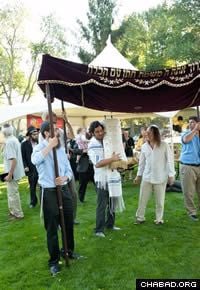 Community members dance with the Torah scroll at the dedication festiviities.