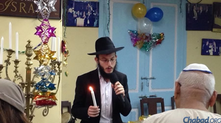 Rabbi Yisroel Kozlovsky lights the menorah at a Chanukah party for the local Jewish community at the Knesset Eliyahu synagogue.