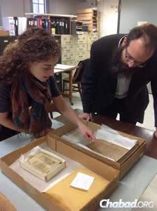 Rabbi Yossi Brackman and Rachel Schine examine a medieval Judeo-Arabic manuscript written in Baghdad from the institute&#39;s collections. (Photo: Jack Green)