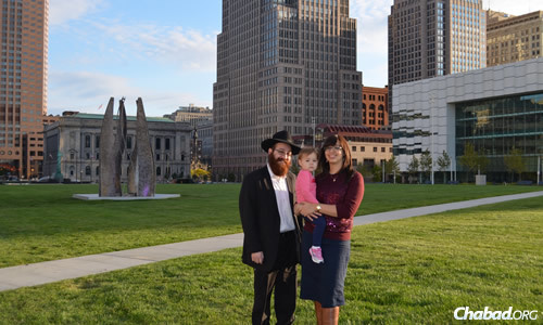 Rabbi Yossi and Chaya Freedman, co-directors of Chabad of Downtown Cleveland, with their daughter Nechama. The couple won one of the new Torahs donated by the Farkas family as part of a recent lottery.