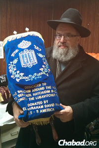 Rabbi Levy Wineberg with the Torah he picked up in New York and is now using in Johannesburg, South Africa. (Photo: Merkos Suite 302)