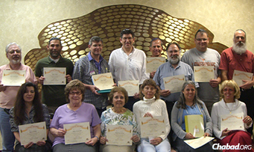 Participatants of a Rohr Jewish Learning Institute (JLI) class, taught at Chabad, proudly display their certificates of completion.