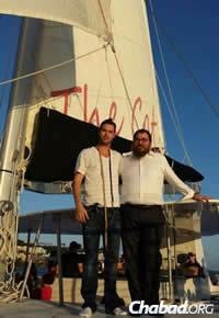 Rabbi Asher Federman assists a man putting on tefillin while boating off St. Thomas.