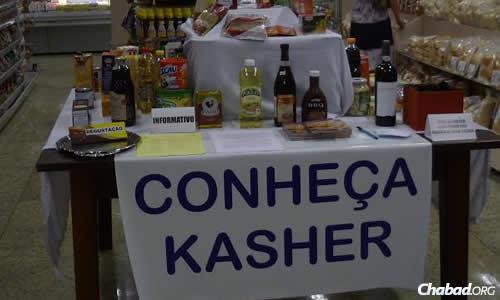 A sign, "Conheça Kasher ("Know Kosher" in Portuguese)," advertises kosher week and products at a nearby store
