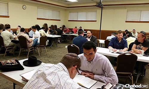 A room full of people participate in a new program called Bais Medrash Boker, an early-morning study hour before 6:30 a.m. prayers in Skokie, Ill.