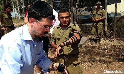 While in Israel, the rabbi visited troops on the Gaza border, wrapping tefillin with them and offering words of support.