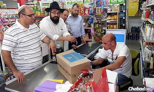  When the group heard of hungry families in Sderot, they went to the supermarket to buy and then distribute pasta, chicken and other foods. Kaplan is second from left; at the far right is Rabbi Yossi Swerdlov of the Chabad Terror Victims Project.