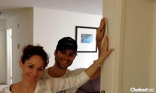A California couple after having their first mezuzah affixed to the doorpost of their home.