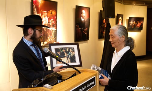 Rabbi Motti Seligson, director of media relations for Chabad-Lubavitch, presents a framed photo gift to artist Chie Nishio of her receiving a piece of "lekach," or honey-sweetened holiday cake, 26 years ago from the Rebbe, Rabbi Menachem M. Schneerson, of righteous memory. (Photo: Gregg Richards)