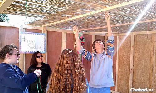 Adolescentes finalizam o teto com sua sechah no topo.