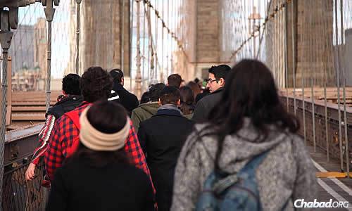 College students walk across the Brooklyn Bridge in a previous year for a tour as part of the many events offered at the annual Chabad on Campus International Shabbaton in New York City, which takes place Friday through Sunday. This year, attendees will ride a double-decker bus to take in the sites of Manhattan. (Photo: Bentzi Sasson)