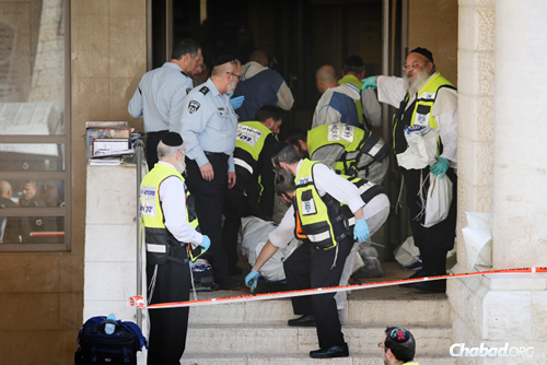 Les sauveteurs israéliens sortent les corps des victimes assassinées par deux terroristes armés qui ont fait irruption dans la synagogue Kehilat Yaakov du quartier de Har Nof à Jérusalem. (Photo: Noam Revkin Fenton/Flash90)