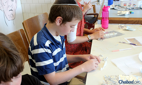 Yisrael Zwiebel makes a menorah as part of a new program called “Dare Yourself: The Maccabee Challenge,” which encourages kids to perform mitzvahs over the eight-day holiday of Chanukah.