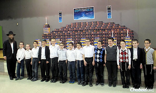 Led by Rabbi Abraham Varnai, fourth-graders at Seymour J. Abrams Cheder Lubavitch Hebrew Day School in Skokie, Ill., build a giant menorah this year made out of other menorahs. honoring the memory of Rabbi Daniel Moscowitz.