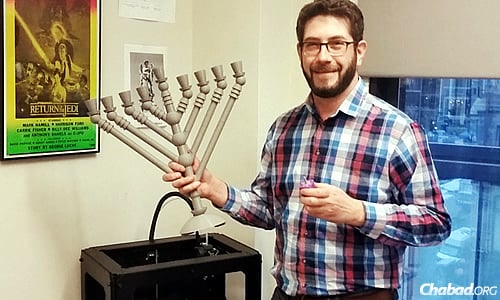 Jared Leavitt holds the menorah he printed on a MakerBot Replicator 2 Desktop 3D printer.