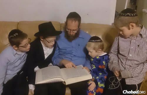 Studying Torah with his children.