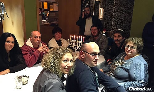 Rabbi Sholom Gopin, standing in center, chief rabbi and Chabad emissary of Lugansk, Ukraine, spends time in Ashdod, Israel, during Chanukah with former members of his community who left because of the war back home.