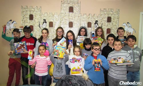 Kids at the Jewish after-school program in Mariupol show off their Chanukah presents.